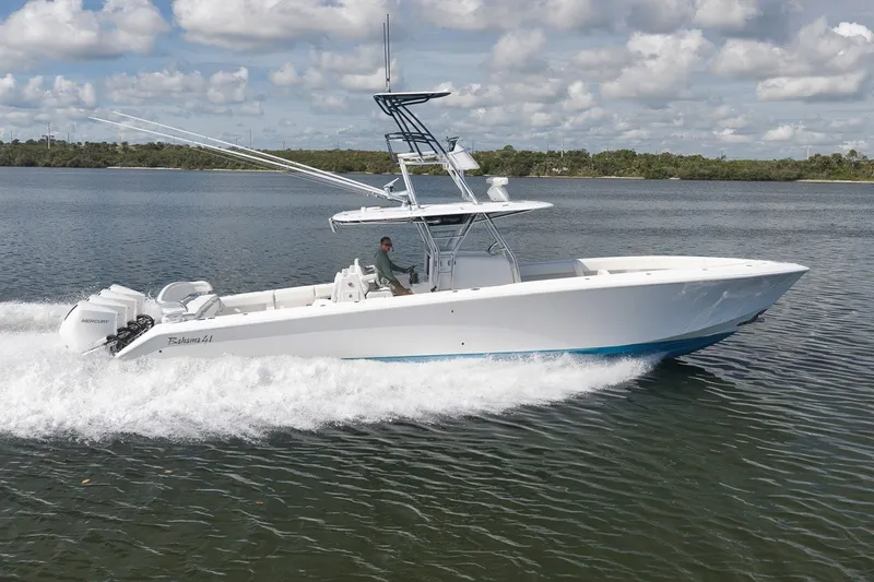 Slide: The Image of 2020 Bahama 41 boat cruising on a calm lake under a partly cloudy sky. - 17