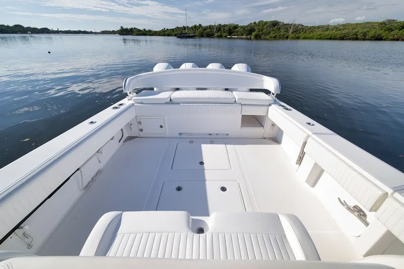 Slide: The Image of 2020 Bahama 41 boat with spacious deck, white seating, and serene water backdrop. - 38