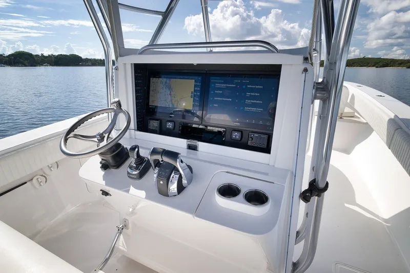 Slide: The Image of Control console of a 2020 Bahama 41 boat with navigation screens and steering wheel. - 60