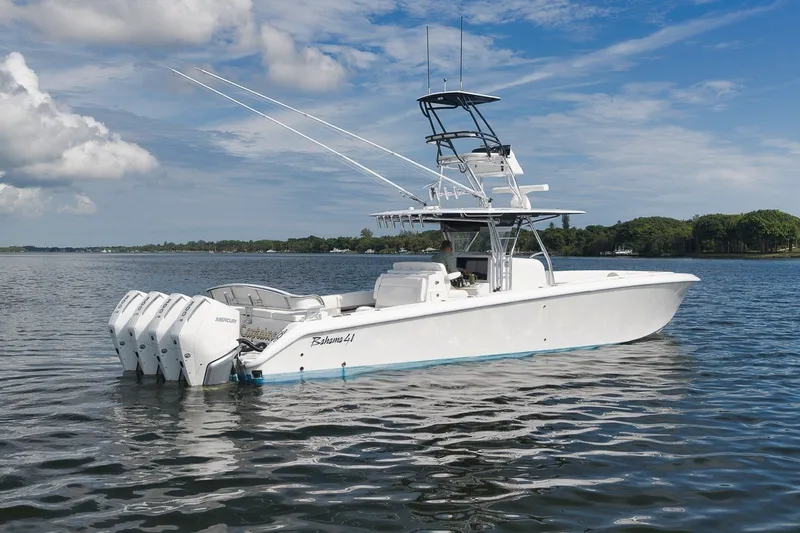 Slide: The Image of 2020 Bahama 41 boat with four Mercury engines on a calm lake under a blue sky. - 2