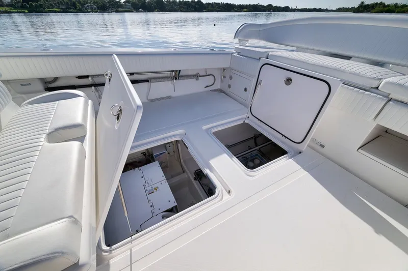 Slide: The Image of 2020 Bahama 41 boat interior with open storage compartments on a calm lake. - 33