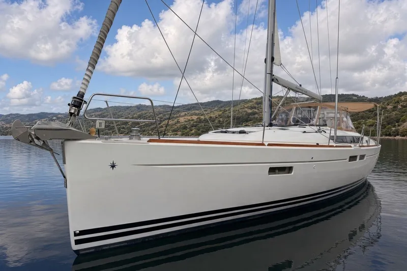 The Image of 2015 Jeanneau Sun Odyssey 469 sailboat on calm water with scenic background. - 1