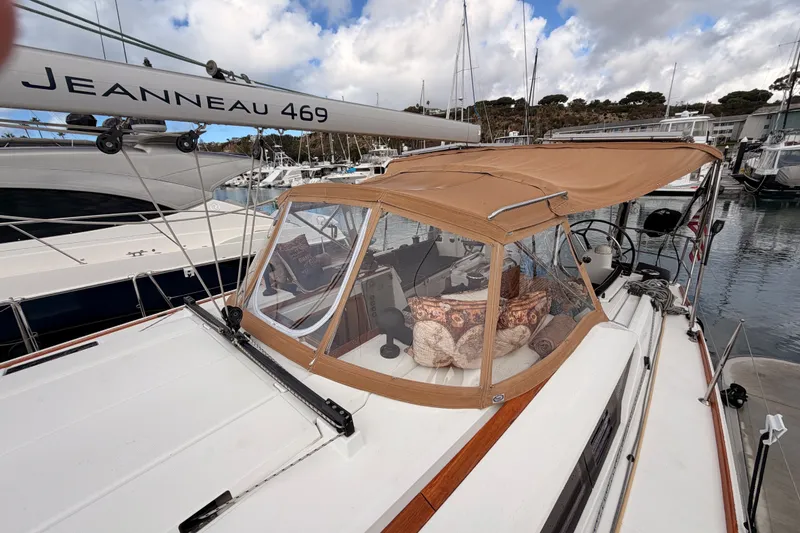 Slide: The Image of 2015 Jeanneau Sun Odyssey 469 sailboat with tan canopy docked in marina. - 19