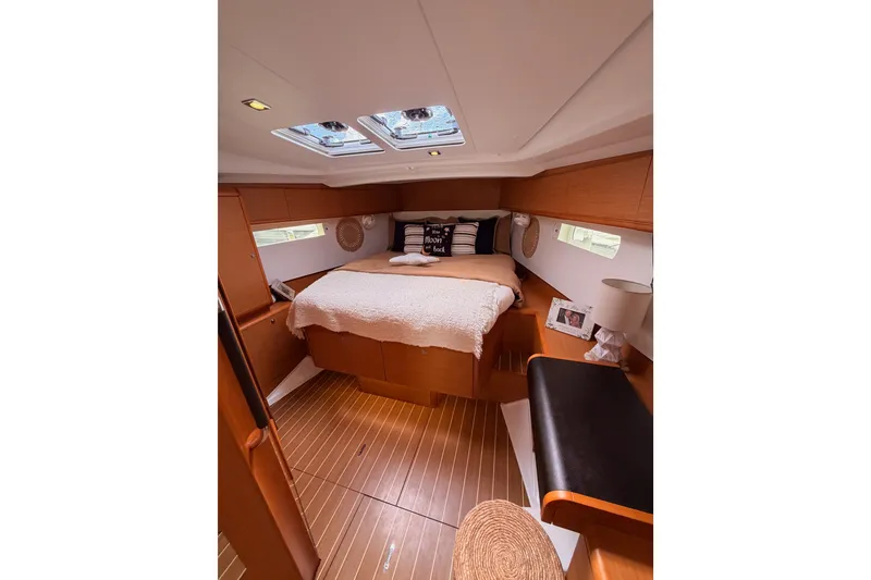 Slide: The Image of Interior cabin of 2015 Jeanneau Sun Odyssey 469 yacht, featuring a cozy bed and wooden decor. - 60