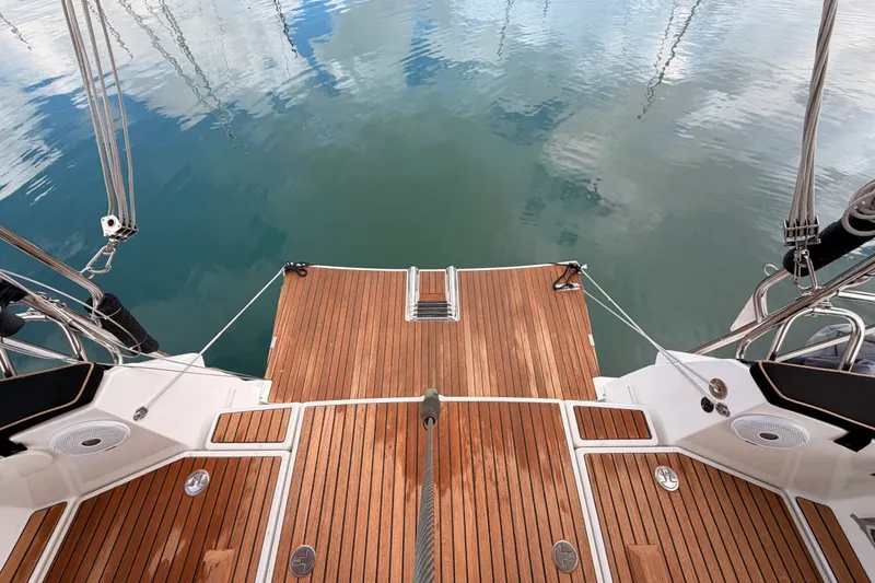 Slide: The Image of Jeanneau Sun Odyssey 469 (2015) yacht deck with teak finish, reflecting calm water. - 24