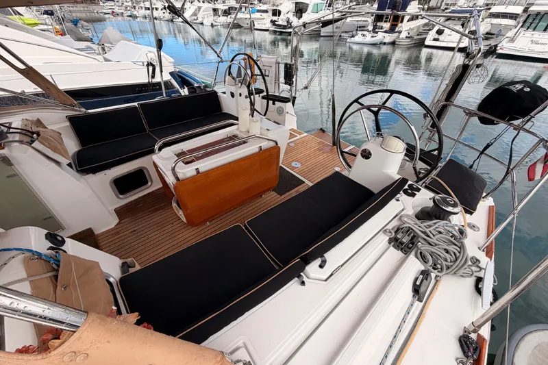 Slide: The Image of Cockpit of 2015 Jeanneau Sun Odyssey 469 yacht, featuring dual steering wheels and sleek seating. - 21