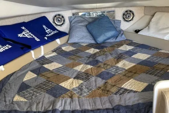 Slide: The Image of Interior cabin of 2004 Bayliner 285 Cruiser with cozy bedding and nautical decor. - 11