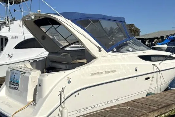 Slide: The Image of 2004 Bayliner 285 Cruiser docked, featuring a sleek design and blue canopy. - 2
