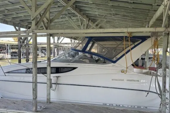 Slide: The Image of 2004 Bayliner 285 Cruiser docked under a wooden shelter. - 4
