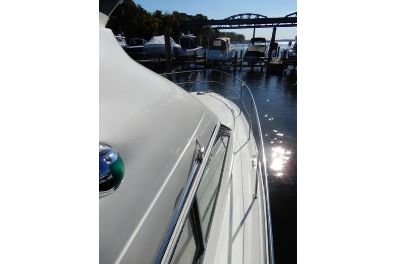 Slide: The Image of 2000 Sea Ray 380 Aft Cabin yacht docked, reflecting sunlight on water. - 33