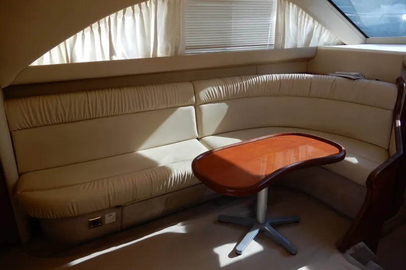 Slide: The Image of Interior of 2000 Sea Ray 380 Aft Cabin with cream seating and wooden table. - 42