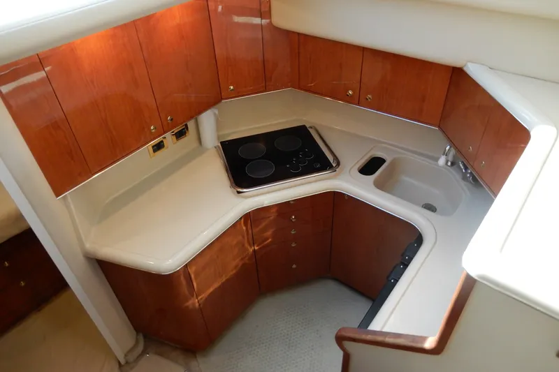 Slide: The Image of Compact kitchen in a 2000 Sea Ray 380 Aft Cabin yacht with wood cabinetry. - 47