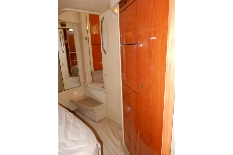 Slide: The Image of Interior of 2000 Sea Ray 380 Aft Cabin with wooden cabinetry and carpeted steps. - 73