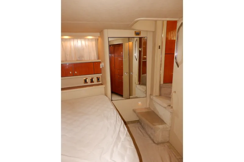 Slide: The Image of Interior of 2000 Sea Ray 380 Aft Cabin with bed, stairs, and wooden cabinetry. - 72