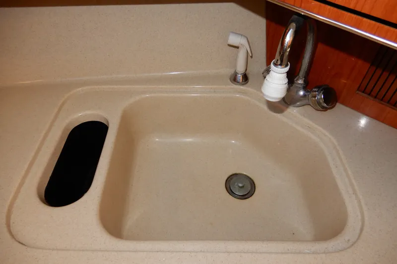 Slide: The Image of Kitchen sink in 2000 Sea Ray 380 Aft Cabin yacht, featuring faucet and countertop. - 52