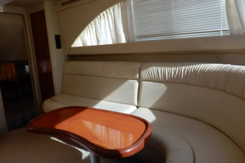 Slide: The Image of Interior of 2000 Sea Ray 380 Aft Cabin with cream seating and wooden table. - 44