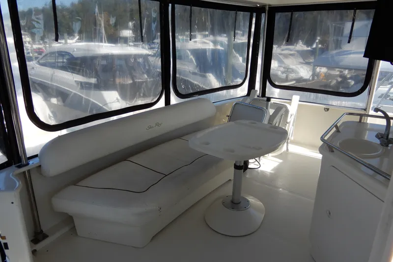 Slide: The Image of 2000 Sea Ray 380 Aft Cabin interior with seating and table, featuring clear windows. - 11