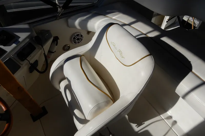 Slide: The Image of Captain's seat on 2000 Sea Ray 380 Aft Cabin yacht, featuring white upholstery and control panel. - 24
