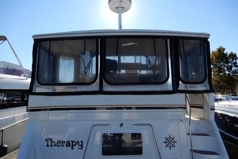 Slide: The Image of 2000 Sea Ray 380 Aft Cabin yacht docked, rear view with "Therapy" name visible. - 8