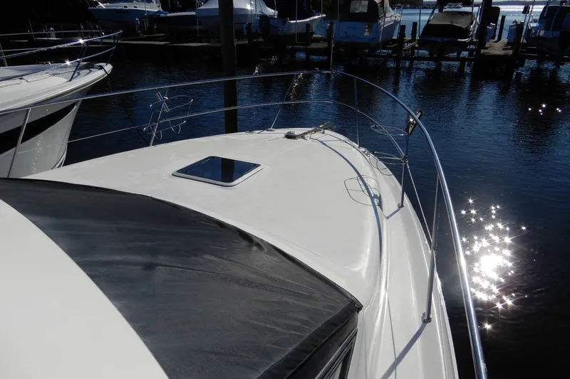 Slide: The Image of 2000 Sea Ray 380 Aft Cabin yacht docked, reflecting sunlight on water. - 34