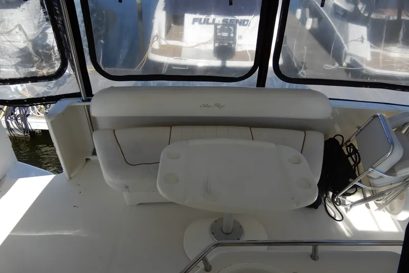 Slide: The Image of 2000 Sea Ray 380 Aft Cabin interior with seating and table, docked at marina. - 10