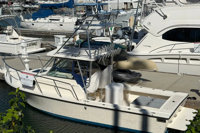 Slide: The Image of 2001 Austin Parker 2510DV boat docked at marina with other vessels. - 2