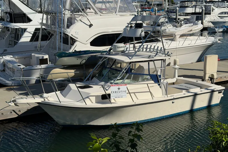 Slide: The Image of 2001 Austin Parker 2510DV boat docked at marina with other vessels. - 1