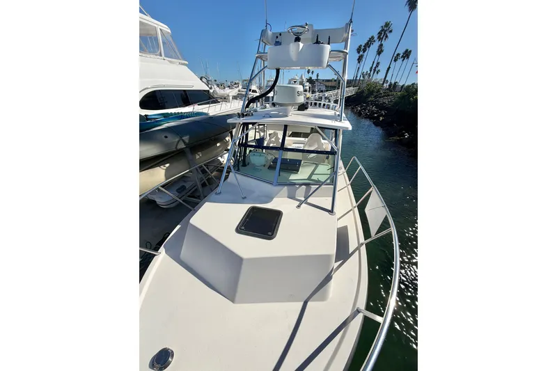 Slide: The Image of 2001 Austin Parker 2510DV boat docked in a marina, sunny day, palm trees in background. - 21