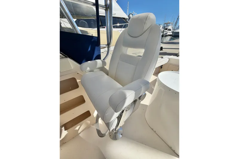 Slide: The Image of Captain's chair on 2001 Austin Parker 2510DV boat, docked under clear blue sky. - 13