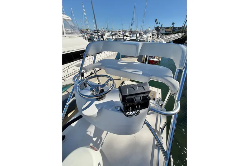Slide: The Image of Helm of 2001 Austin Parker 2510DV boat with steering wheel and controls, docked at marina. - 23