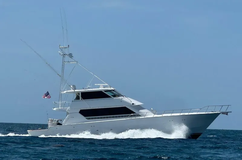 The Image of 1994 Hatteras 82 Convertible yacht cruising on open sea with American flag. - 0