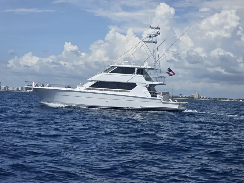 Slide: The Image of 1994 Hatteras 82 Convertible yacht cruising on open water under a cloudy sky. - 34