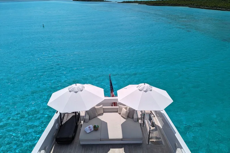 Slide: The Image of Luxurious Delta Marine 110 yacht deck with umbrellas on turquoise water, 1994 model. - 24