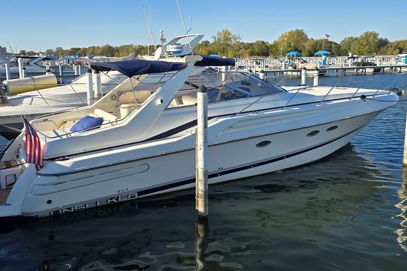 The Image of 1994 Sunseeker Mustique 42 yacht docked at marina, featuring sleek design and American flag. - 1