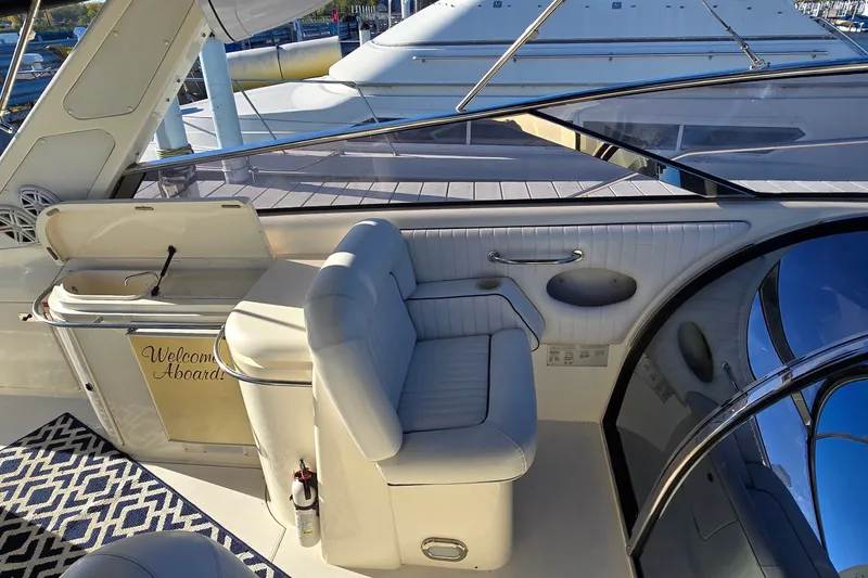 Slide: The Image of Interior of 1994 Sunseeker Mustique 42 yacht with white seating and "Welcome Aboard" sign. - 11