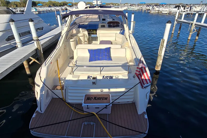 Slide: The Image of 1994 Sunseeker Mustique 42 yacht docked at marina, rear view with American flag. - 3