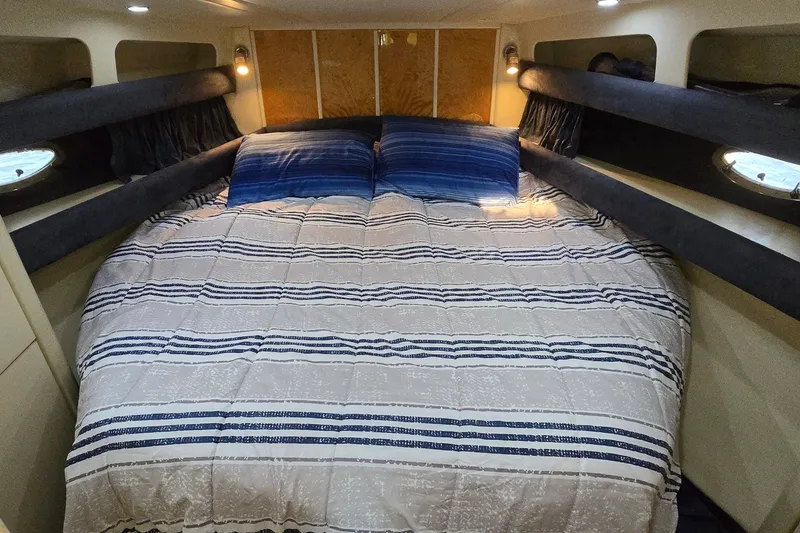 Slide: The Image of Cozy cabin interior of 1994 Sunseeker Mustique 42 with striped bedding and ambient lighting. - 20