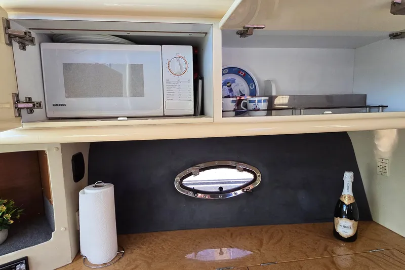 Slide: The Image of Interior of 1994 Sunseeker Mustique 42 yacht with microwave and champagne bottle. - 28