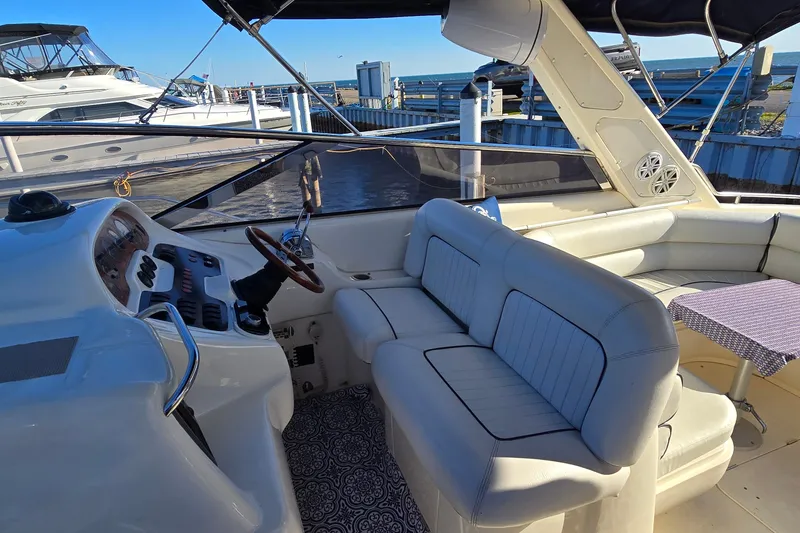 Slide: The Image of 1994 Sunseeker Mustique 42 yacht interior with white seating and helm station. - 9