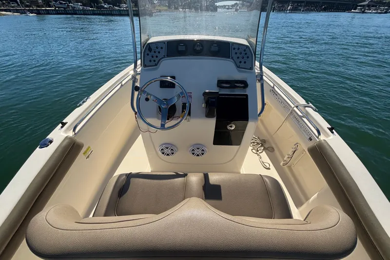 Slide: The Image of 2016 Scout 210 XSF boat interior with steering wheel and seating on calm water. - 11