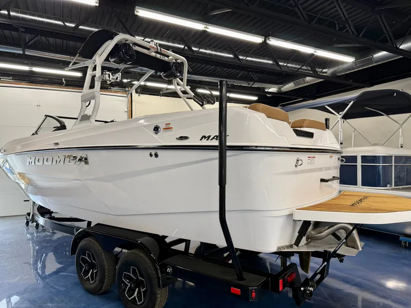 Slide: The Image of A 2026 Moomba Max boat on a trailer in a showroom. - 24