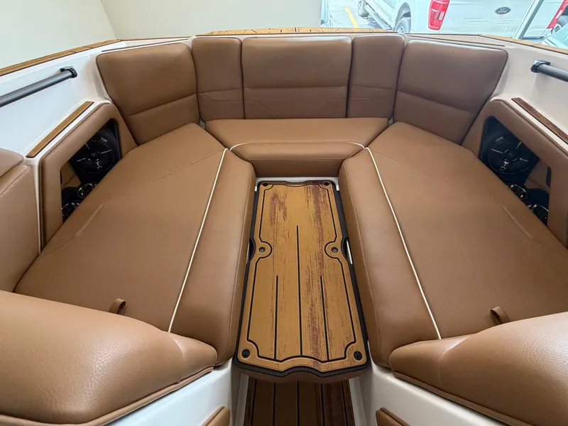 Slide: The Image of Interior of the 2026 Moomba Max with brown upholstery and a wooden table in the center. - 16