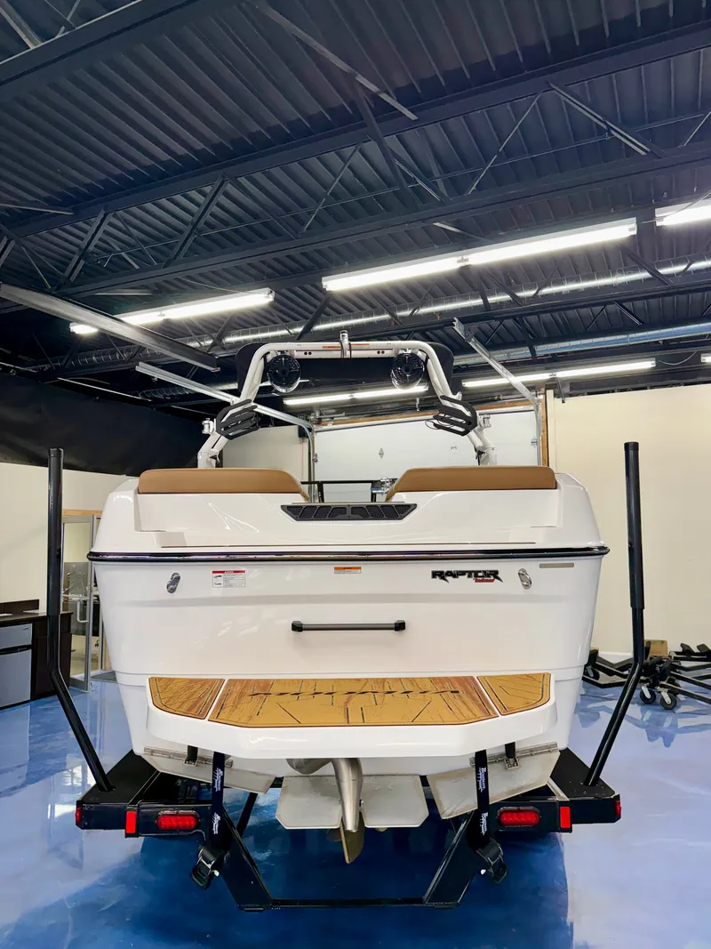 Slide: The Image of The image shows a 2026 Moomba Max boat in a showroom. It features a modern design with a white hull and wooden deck. - 25