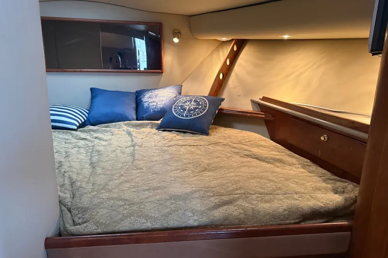 Slide: The Image of Luxurious cabin interior of 2006 Rampage 38 Express with cozy bedding and nautical-themed pillows. - 15