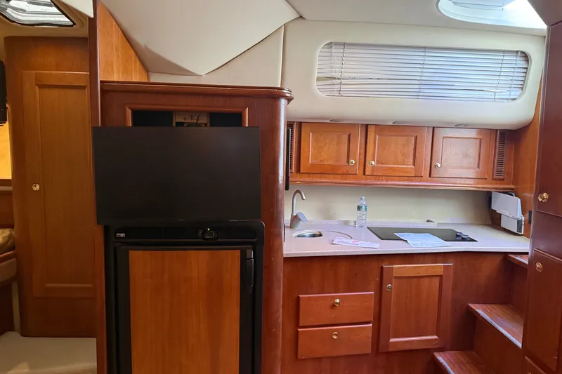 Slide: The Image of Interior of 2006 Rampage 38 Express yacht with kitchenette and wooden cabinetry. - 13