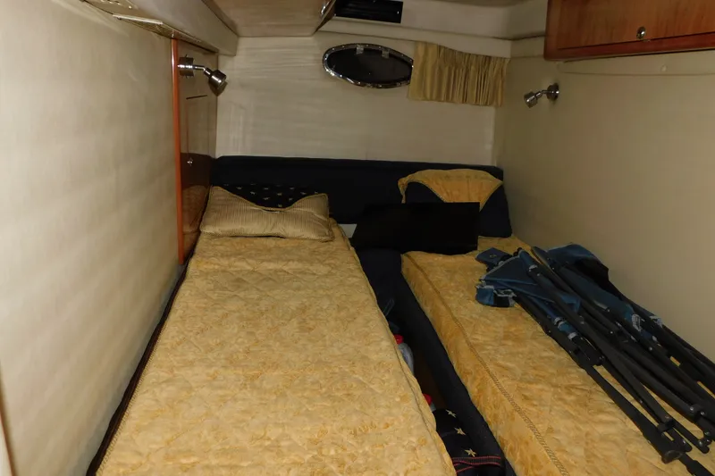 Slide: The Image of Cozy cabin interior of 2004 Regal Commodore 3860 with twin beds and warm lighting. - 91
