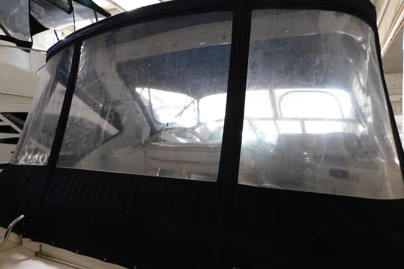 Slide: The Image of 2004 Regal Commodore 3860 boat with clear enclosure in a marina setting. - 22