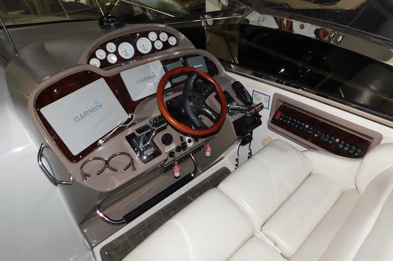 Slide: The Image of 2004 Regal Commodore 3860 helm with Garmin displays and wood-accented steering wheel. - 39