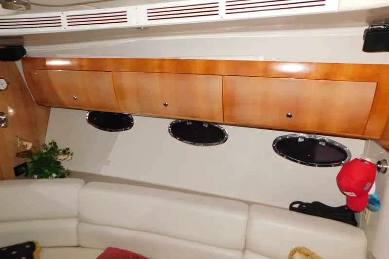 Slide: The Image of Interior of 2004 Regal Commodore 3860 yacht with wooden cabinets and portholes. - 53