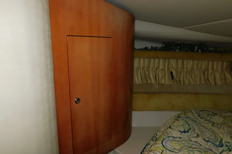 Slide: The Image of Interior of 2004 Regal Commodore 3860 yacht with wooden cabinet and patterned bedding. - 65